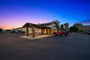 a building with a car parked in a parking lot at Hotel 8 in Fergus Falls