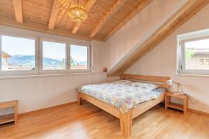 a bedroom with a bed and two windows at Sigelalp in Blaichach