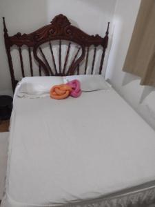 a bed with two dolls sitting on top of it at Casa lai in Rio de Janeiro