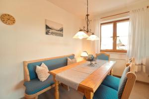 a dining room with a wooden table and blue chairs at StaigAllgäublick in Sonthofen