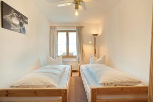 two twin beds in a room with a window at StaigAllgäublick in Sonthofen +6 photos
