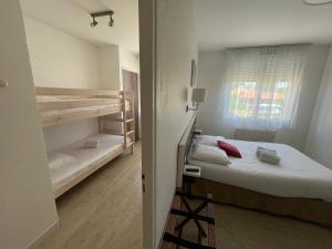 a room with a bed and two bunk beds at Auberge Les Mufliers - Hôtel Les Forges in Pontenx-les-Forges