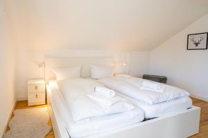 a white bed with white sheets and pillows on it at Spitzkehren in Blaichach