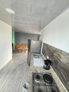 a kitchen with a stove and a dining room at Apartamentos campestres la Divisa in Santa Rosa de Cabal