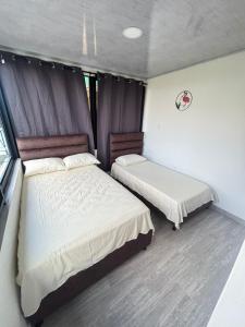 a bedroom with two beds and a window at Apartamentos campestres la Divisa in Santa Rosa de Cabal +3 photos