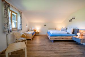 a bedroom with two beds and a table and a chair at Landhaus Waibel in Blaichach