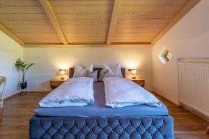 a bedroom with a large blue bed with two lamps at Landhaus Waibel in Blaichach