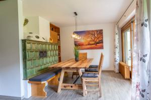 a dining room with a wooden table and chairs at Bergfink in Waltenhofen