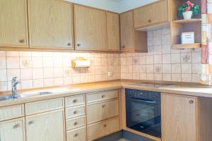 a kitchen with wooden cabinets and a sink at Bergfink in Waltenhofen