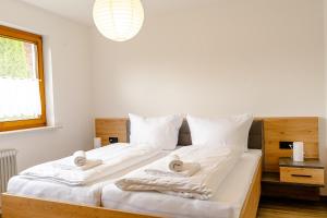 a bedroom with a large bed with towels on it at Bergfink in Waltenhofen
