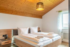 a bedroom with a large bed with a wooden ceiling at Bergfink in Waltenhofen +7 photos