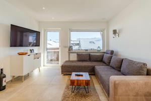 a living room with a couch and a flat screen tv at Fewo Blick in die Berge in Ofterschwang