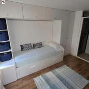 a white room with a couch with two pillows on it at Villa Dimarts- a 100m de playa in Gandía