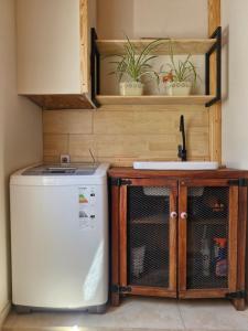 a kitchen with a refrigerator and a sink and a dishwasher at Rincón del Shoam in Gobernador Gregores