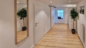 a hallway with a mirror and two potted plants at Chalet 44 in Ofterschwang