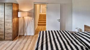 a bedroom with a bed and a hallway with a staircase at Chalet 44 in Ofterschwang