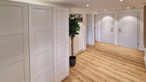 a hallway with white closet doors and a potted plant at Chalet 44 in Ofterschwang +16 photos
