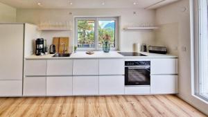 a kitchen with white cabinets and a window at Chalet 44 in Ofterschwang