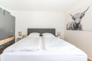 a bedroom with a bed with a picture of a cow at Gipfelliebe in Bad Hindelang