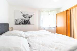 a bedroom with a bed with a picture of a bull at Gipfelliebe in Bad Hindelang