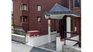 a building with a porch and a building with a roof at Le Cervin Lodge in Breuil-Cervinia