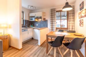 a kitchen and dining room with a wooden table and chairs at Bergfriede in Bad Hindelang