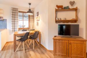 a living room with a dining room table with a television at Bergfriede in Bad Hindelang +9 photos