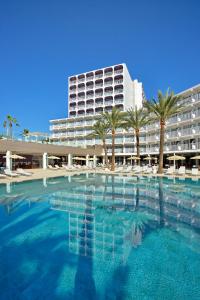 a large swimming pool with palm trees and a large building at Sol House The Studio - Calviá Beach - Adults Only in Magaluf