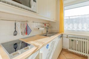 a kitchen with white cabinets and a sink and a window at Ifen in Fischen