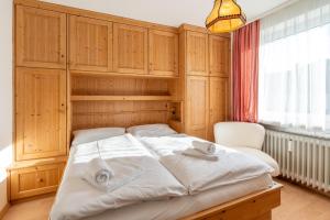 a bedroom with a large bed with wooden cabinets at Ifen in Fischen
