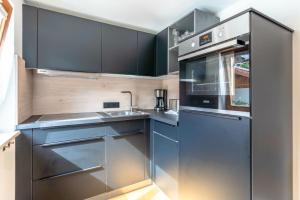 a kitchen with stainless steel appliances and black cabinets at Stolz 1 in Blaichach