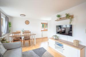 ein Wohnzimmer mit Sofa und ein Esszimmer in der Unterkunft Stolz 2 in Blaichach