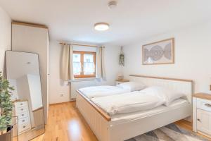 ein Schlafzimmer mit einem weißen Bett und einem Spiegel in der Unterkunft Stolz 2 in Blaichach + 3 Fotos