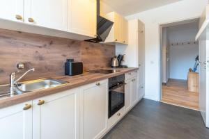 a kitchen with white cabinets and a sink at Bergerwachen in Bolsterlang