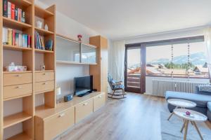 a living room with a blue couch and a tv at Bergerwachen in Bolsterlang
