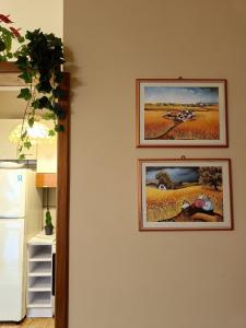 two pictures hanging on a wall in a kitchen at Fimar in Torre Lapillo +42 photos
