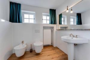 a bathroom with two sinks and a toilet and a mirror at Landhaus Hoch 10 in Burgberg