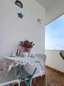 a table with a vase of flowers on it at Fimar in Torre Lapillo