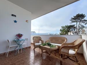 a balcony with chairs and a table and a table at Fimar in Torre Lapillo