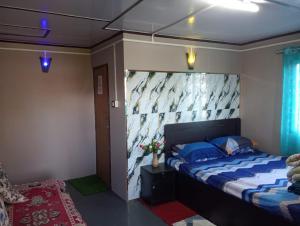 a bedroom with a bed with a large headboard at MountainBrew Homestay in Takdāh