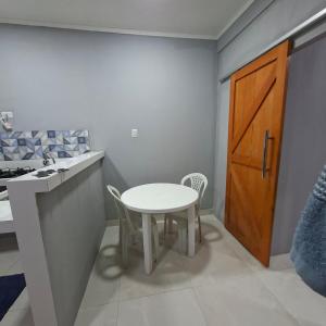 a kitchen with a table and a sink and a door at Espaço completo aconchegante no 2 andar in Belém