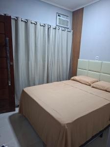 a bedroom with a bed with a curtain and a window at Espaço completo aconchegante no 2 andar in Belém