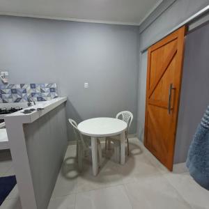a kitchen with a white table and a wooden door at Espaço completo aconchegante no 2 andar in Belém +18 photos