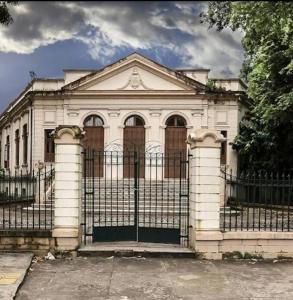 a white house with a gate in front of it at Espaço completo aconchegante no 2 andar in Belém