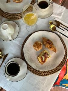 a table with two plates of food and glasses of wine at REFUGIO do SAGRADO MORERE Tropical Lodge - A CASA das BRUXAS in Moreré