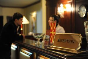 un bar avec un panneau indiquant la réception dans l'établissement Millenium Palace, à Ohrid