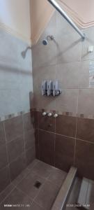 a bathroom with a shower with brown tile at Departamento Completo con Cochera, Comodo y Tranquilo in San Fernando del Valle de Catamarca