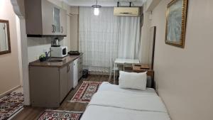 a small room with a bed and a kitchen at Burak Apart in Istanbul