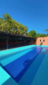 a blue swimming pool with trees in the background at Villas victoria mirador in Zihuatanejo