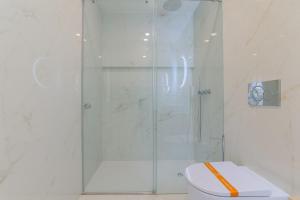 a bathroom with a glass shower with a toilet at D'AUSE - New Modern Apt - 150m to Beach & Center in Esposende +3 photos